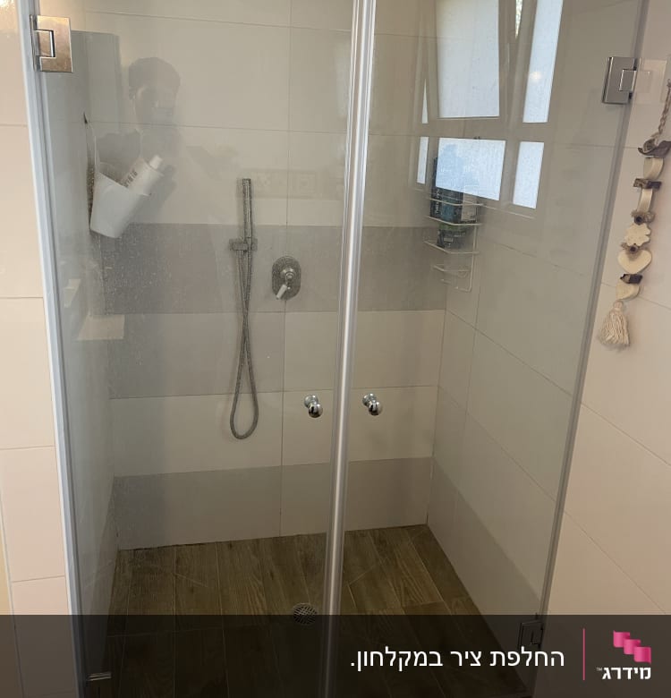 מקלחון זכוכית עם ראש מקלחת ומדף מוצרים